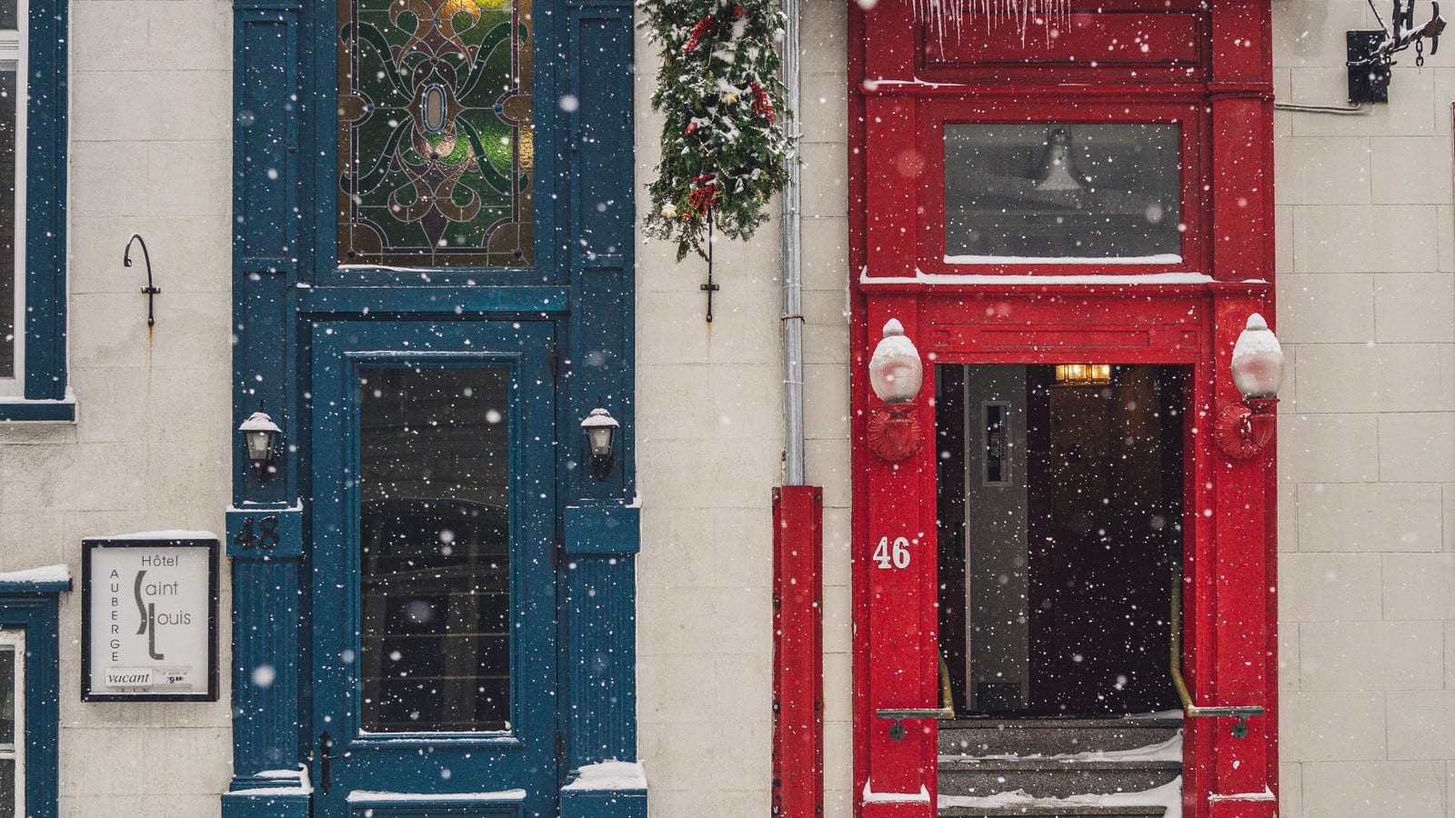 Colourful doors of an Old Quebec building under falling snow